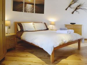 CoedanaThe Windmill的一间卧室配有一张带白色床单的大床