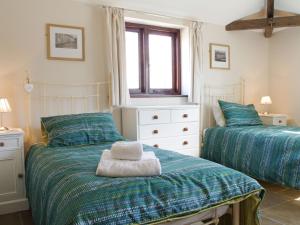 West LuttonThe Old Forge的一间卧室设有两张单人床和一个窗户。