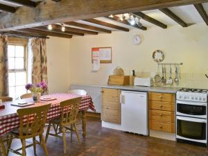 Branthwaite玉米磨坊乡村别墅酒店的厨房以及带桌椅的用餐室。