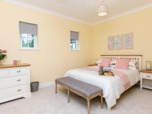 门蒂斯港Graces Cottage的卧室配有一张带粉红色枕头的大床