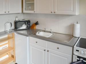 霍宁塔卡拉乡村别墅的厨房柜台设有水槽和微波炉