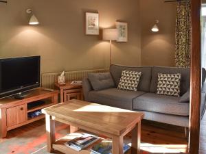 Far SawreyLetterbox Cottage的带沙发和电视的客厅