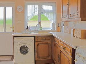 PotterneAbbotts Ball Farm的厨房配有水槽和洗衣机