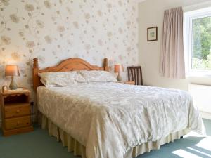 PotterneAbbotts Ball Farm的卧室配有一张带白色棉被的床和窗户。
