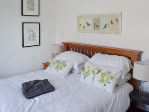 SoutergateWoodburn Cottage的一间卧室配有带白色床单和枕头的床。