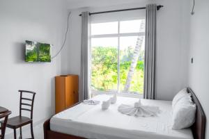 卡图纳耶克G A Villa Airport Transit Hotel的一间卧室配有一张带窗户和椅子的床