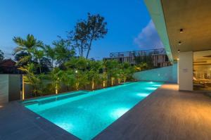 奥南海滩CORNER SEA VIEW KRABI Ao Nang 4 STARS HOTEL RESIDENCE的夜间别墅内的无边泳池