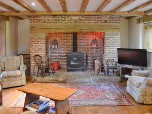 米德尔顿万若艾世思乡村别墅的客厅设有砖砌壁炉和电视。