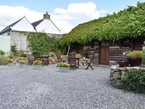米德尔赫姆Foal Barn Cottages - Hayloft - Spennithorne的小屋前面设有椅子和植物