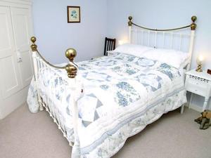 Loders苹果树乡村别墅的一间卧室配有一张带白色和蓝色棉被的床