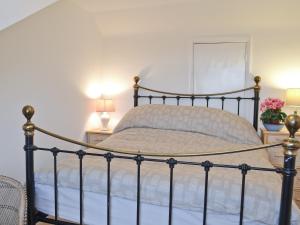 Fordwich雪松乡村别墅的一间卧室配有一张带两盏灯和鲜花的床。