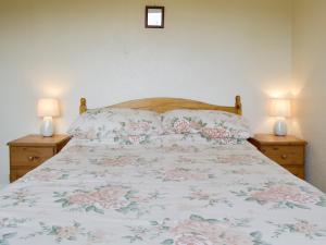 Pilton沃尔特斯别墅酒店的一间卧室配有一张带花卉床罩和两盏灯的床。