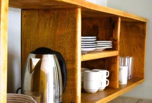 布韦朱Maryam Garden Apartments & Villa的木柜,配有咖啡壶和盘子