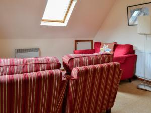 水上伯顿红陶别墅的客厅配有两把椅子和一张沙发