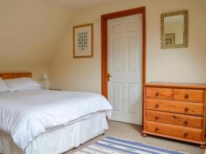 水上伯顿红陶别墅的一间卧室配有一张床、梳妆台和镜子