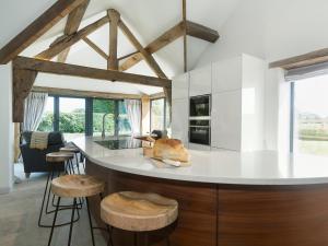 BerkleyPuddledock Piggery的厨房配有白色台面和木凳