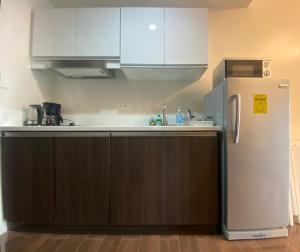 马尼拉Air Residences 4439的厨房配有白色橱柜和冰箱。