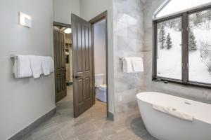 比弗河Ski In Ski Out Rocky Mountain Townhome的白色的浴室设有浴缸和窗户。