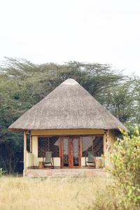 马赛马拉Olaloi Mara Camp的凉亭配有椅子和草屋顶
