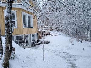 基尔科努米Sydåbacka Guest House, a Room with a Sauna的旁边那座有雪的房子