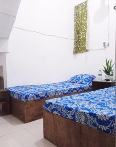 SintangGreenKOST的配有两张蓝色和白色床单的床铺