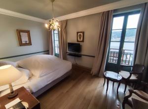 热拉梅湖庄园酒店的一间卧室配有一张床、一张书桌和一台电视