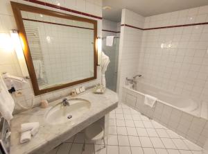 热拉梅湖庄园酒店的一间带水槽、浴缸和镜子的浴室