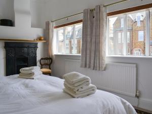 亨斯坦顿女主人之家度假屋的一间设有白色毛巾的床的房间
