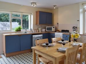 JohnstonPopehill Farm Apartment的厨房配有木桌和蓝色橱柜。