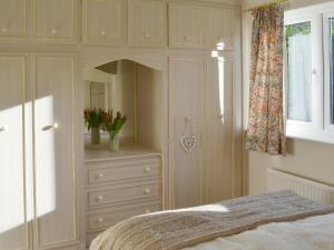 朗里奇Carmichael的一间卧室配有一张床、一个梳妆台和一扇窗户。