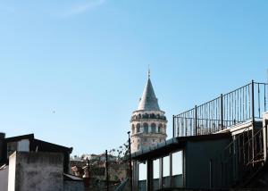 伊斯坦布尔Galata Master Hotel的一座高高的塔楼,楼顶上有一陡峭的陡峭