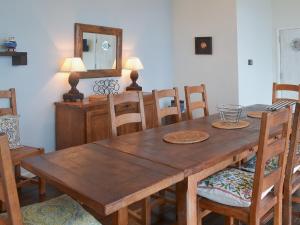 Strete海上悬崖小屋的木制用餐室配有桌椅和镜子