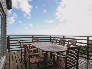 Strete海上悬崖小屋的甲板上的木桌和椅子,享有海景