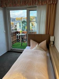 维林根Sevda's Hotel Garni Weinforth的一间卧室设有一张床和一个大窗户