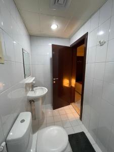 迪拜Pharaohs Inn Deira Hostel的白色的浴室设有卫生间和水槽。