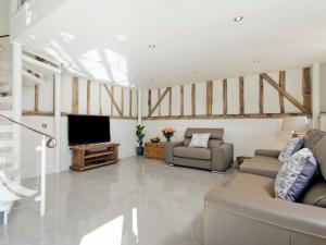BradwellTatters Barn的客厅配有2张沙发和1台平面电视