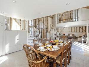 BradwellTatters Barn的厨房以及带木桌和椅子的用餐室。