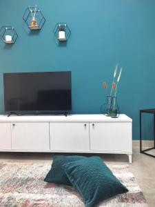 克罗托内Jòia Holiday Home的客厅配有白色梳妆台,蓝色墙壁上配有电视