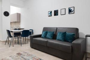 克罗托内Jòia Holiday Home的客厅里配有带蓝色枕头的黑色沙发