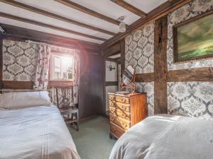 Trefeglwys佩恩克比乡村别墅的一间卧室配有两张床和梳妆台。