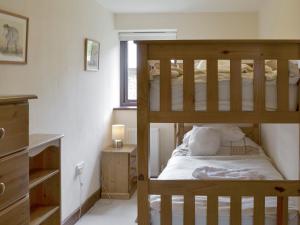 Poundstock霍姆蕾乡村别墅的一间卧室设有两张双层床和一扇窗户。