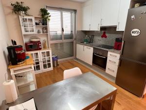 拉科鲁尼亚Loft con PARKING "Hygge Urbano Coruña"的厨房配有白色橱柜和不锈钢冰箱