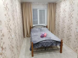 乌斯季卡缅诺戈尔斯克Lux Home на Амурской的一张小床,上面有一双粉色的鞋