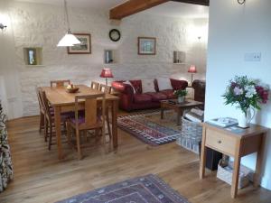 BaltonsboroughBrook Cottage的客厅配有桌子和沙发