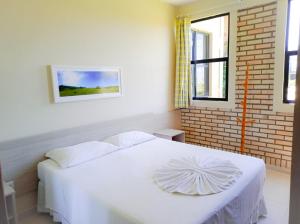 因比图巴野海滩酒店的砖墙房间内的一张白色床