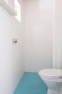 莫勒松德Kvarnstugan的浴室铺有蓝色地板,设有白色卫生间。