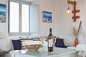 阿诺梅拉Antheia Suite of Mykonos的客厅配有带酒瓶和玻璃杯的桌子