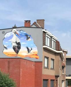 屈尔内Gasthuis 20 verdiep 2的大楼一侧有鸟的大广告牌