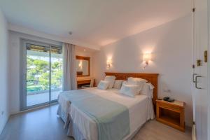 穆罗海滩Playa Esperanza Resort Affiliated by Meliá的一间卧室设有一张床和一个大窗户