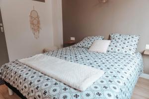 布鲁瓦Le petit rempart - Appt lumineux 2pers au coeur de Blois的一间卧室配有一张带蓝色和白色棉被的床